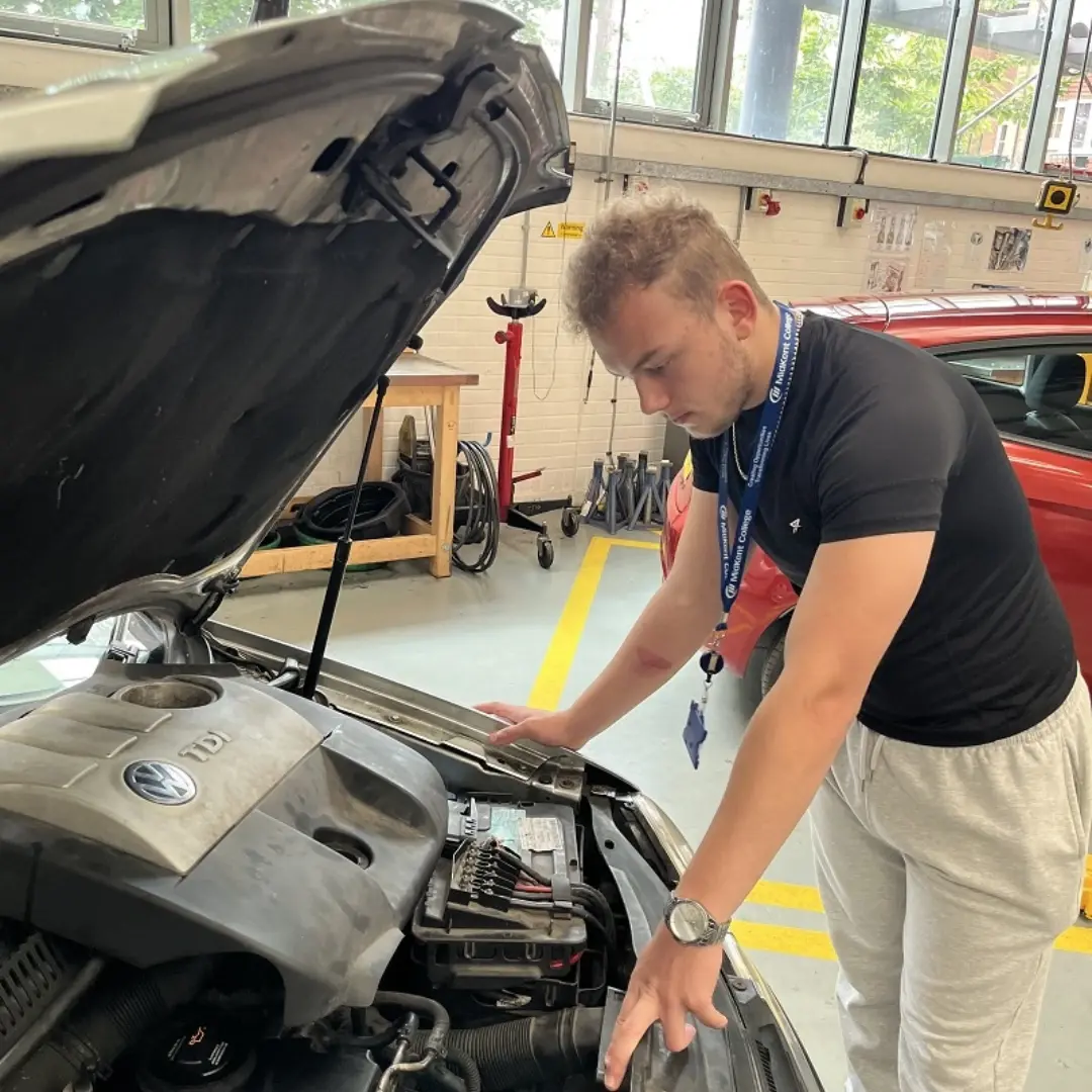 Student working on a car with the bonnet up