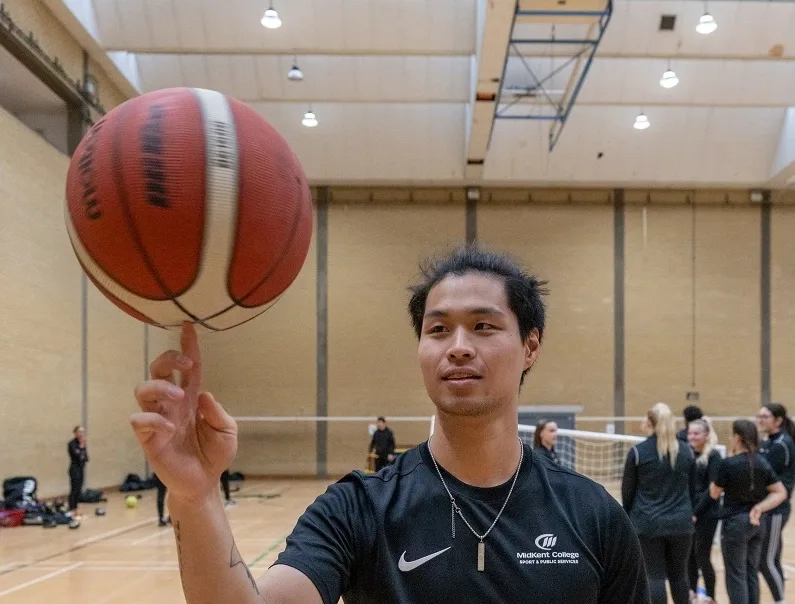 Sports student spinning basketball on their finger