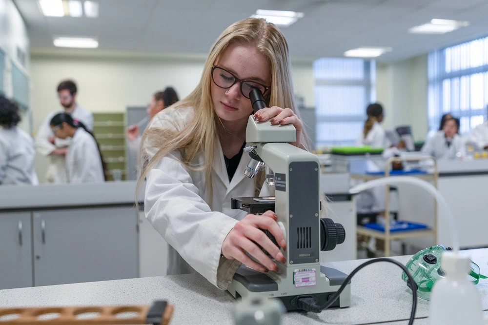 Science student looking through telescope
